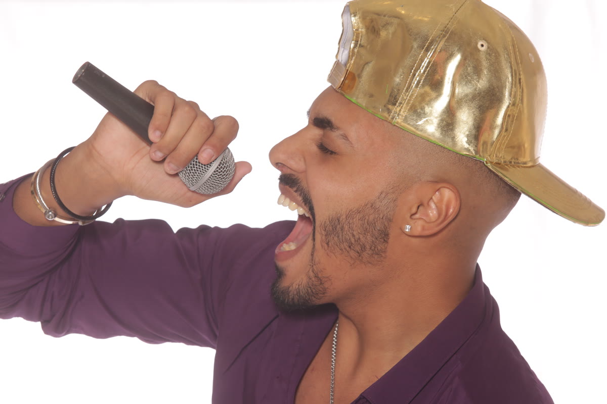 מאור גמליאל שר עם מיקרופון, כובע זהב, צילום סטודיו